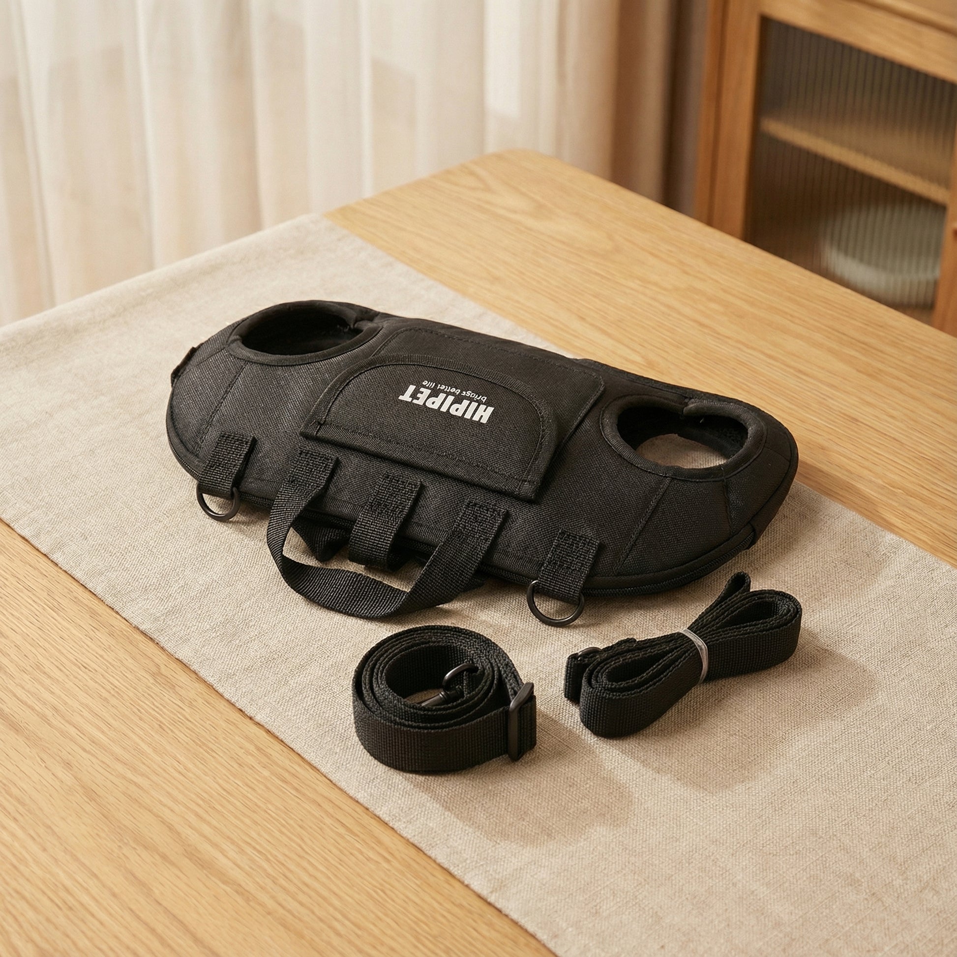 黒色の抱っこ紐ハーネス（超軽量エアリフト多機能）｜PetoPop製｜布製のベージュ色のランチョンマットに、ストラップとハンドル付き