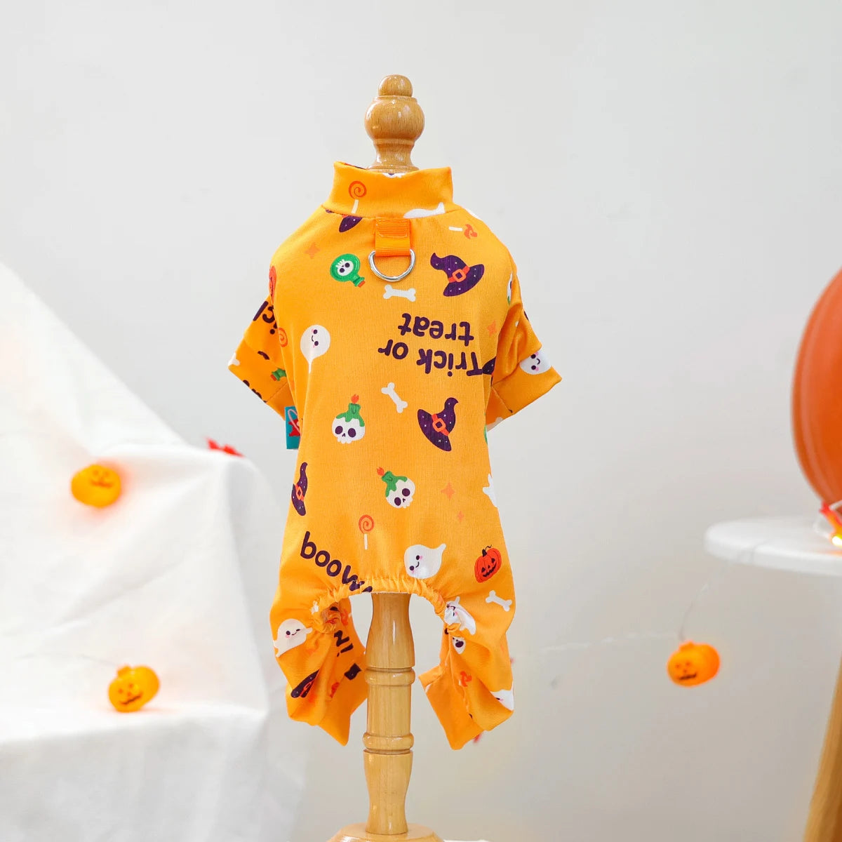 オレンジ色の犬用ペット服(Petopop)は、ハロウィーンのモチーフとテキストがプリントされています。