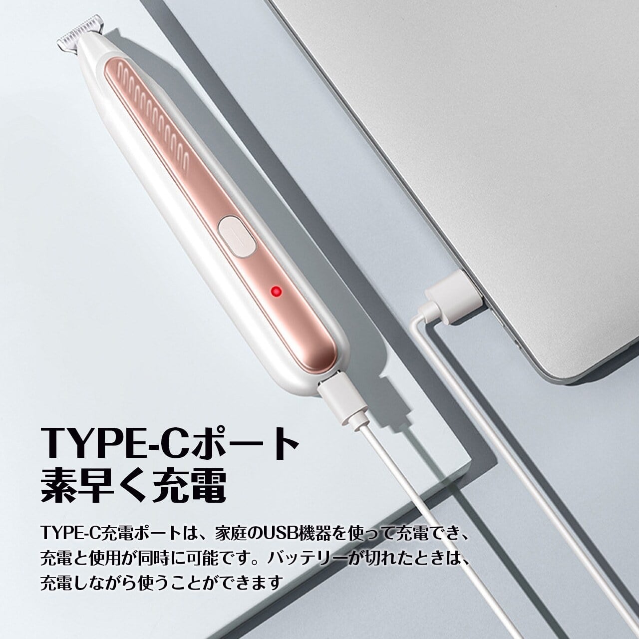 白とローズゴールドのペット用バリカン（足裏トリマー）by PetoPop, 充電ケーブルでノートパソコンに接続されている様子