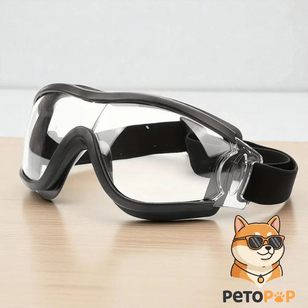 黒いペット用ゴーグル（曇り止め、防風防塵） by Petopop、犬猫用アイウェア、テーブルに置かれた正面図